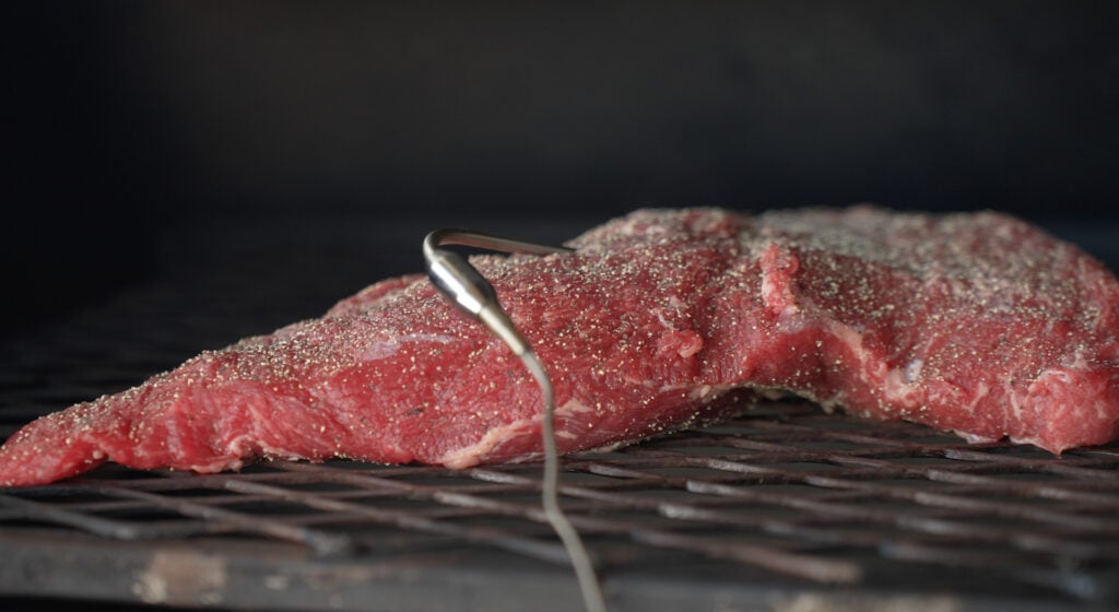 tri tip laying on the smoker grates