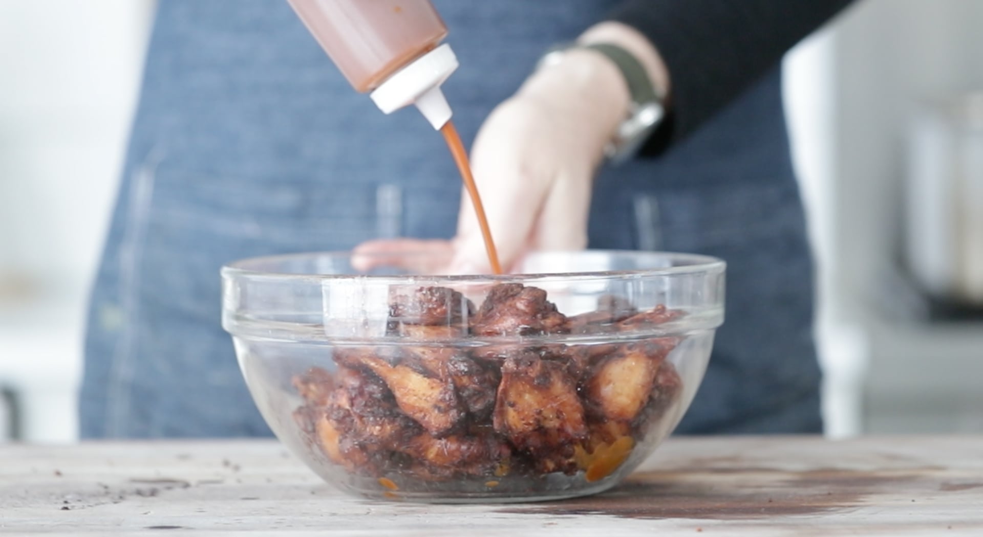 adding bbq sauce to smoked chicken wings