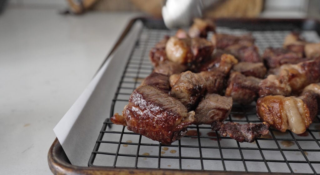 cooked steak bites cooling on a rack