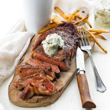 sliced steak with herb butter and fries
