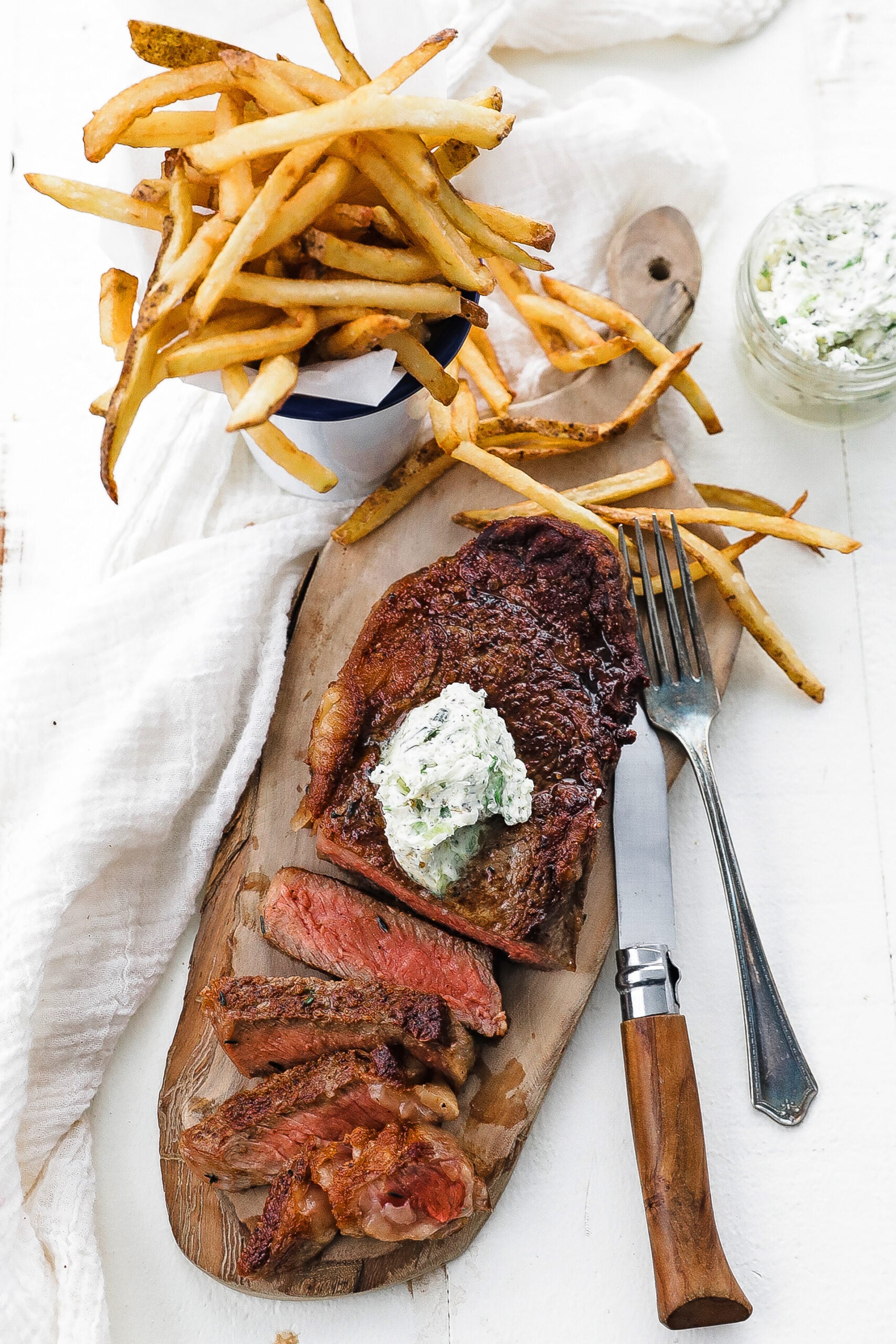 sliced steak with herb butter and fries