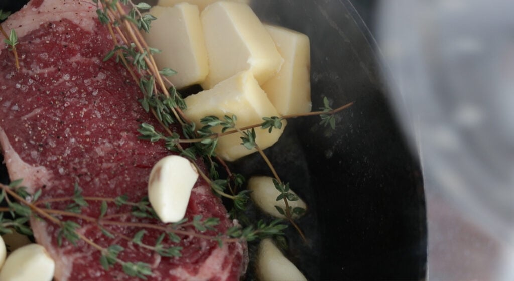 basting the steak with garlic, thyme and butter