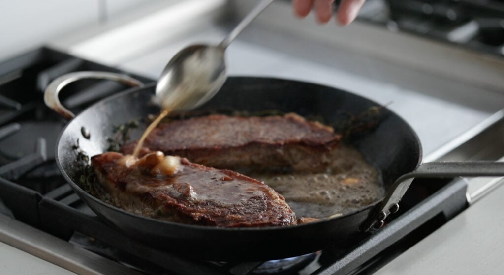 searing the steak in a skillet