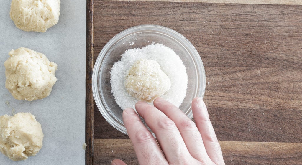 One cookie dough ball in a bowl full of sugar