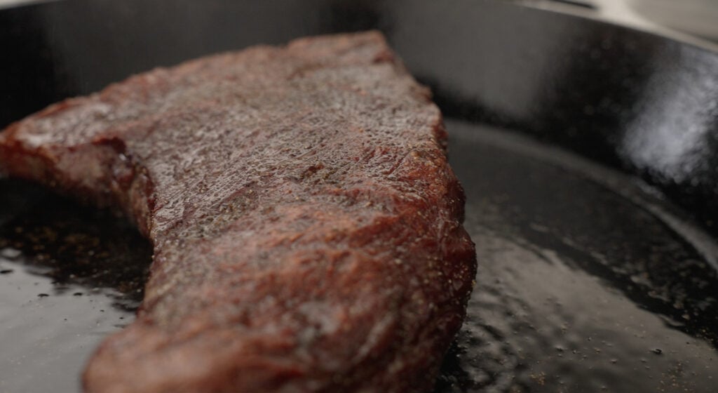 a browned steak in a pan
