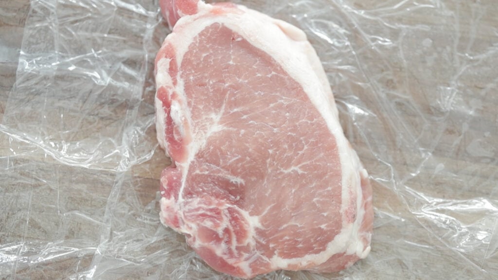 pounding and tenderizing a pork chop
