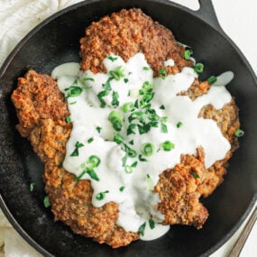 cast iron skillet with chicken fried steak and gravy