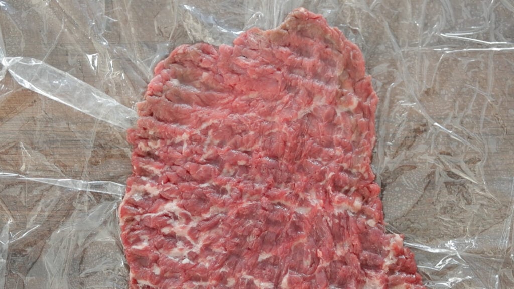 pounded cube steak on a cutting board