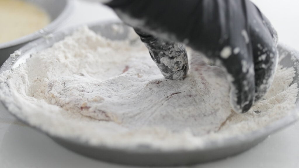 dredging a steak in a seasoned flour
