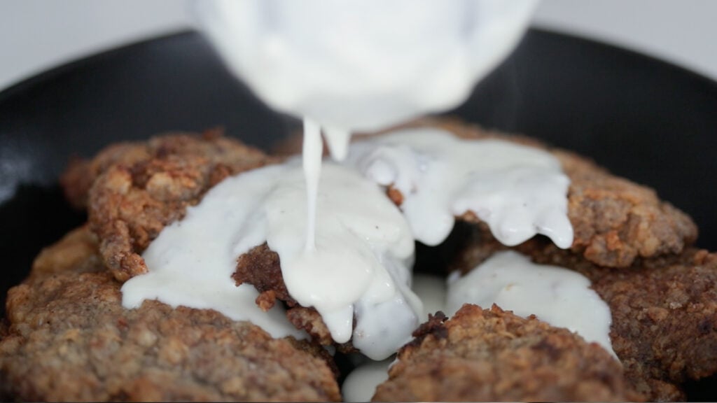 adding herbs to chicken fried steak with gravy