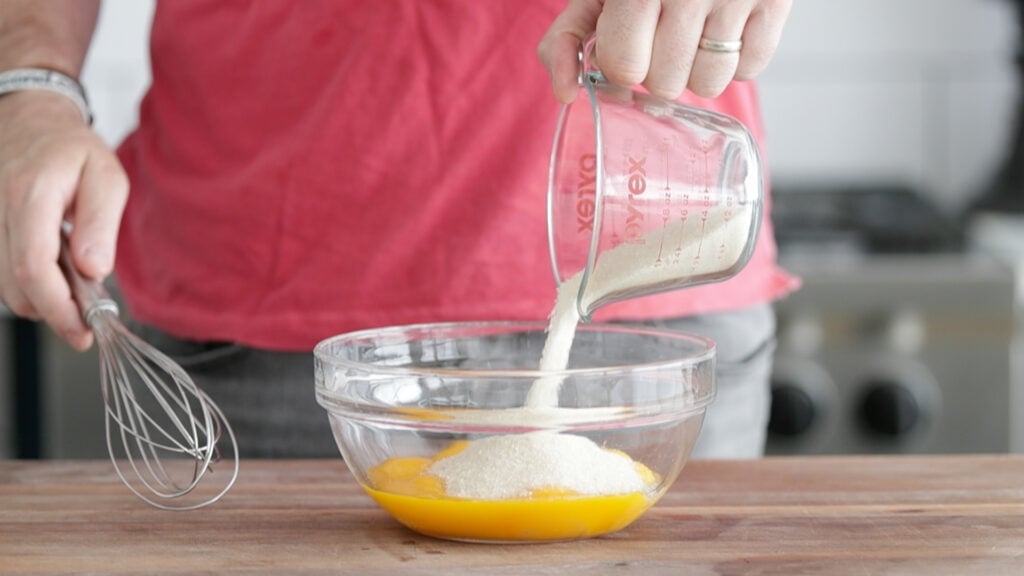 adding sugar to the egg mixture