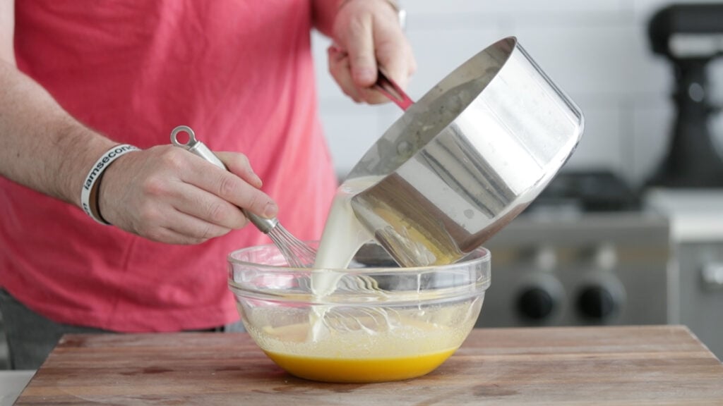adding cream to the eggs yolks mixture