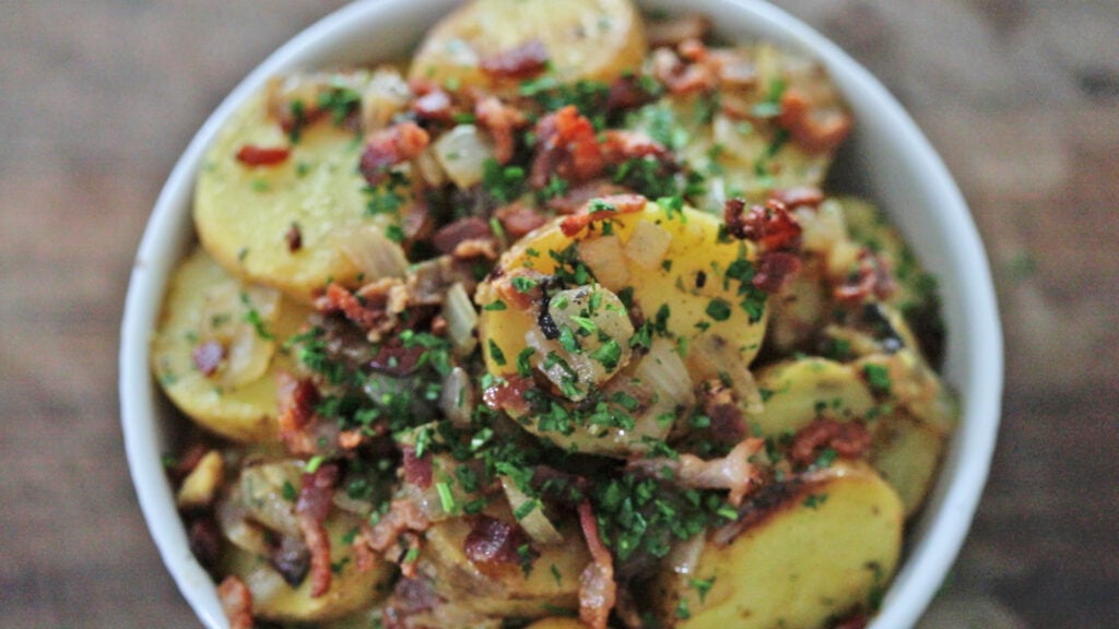 garnishing german potato salad with parsley
