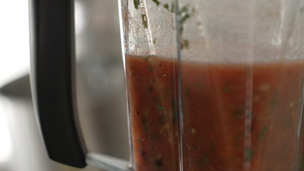 side view of blended salsa in a blender
