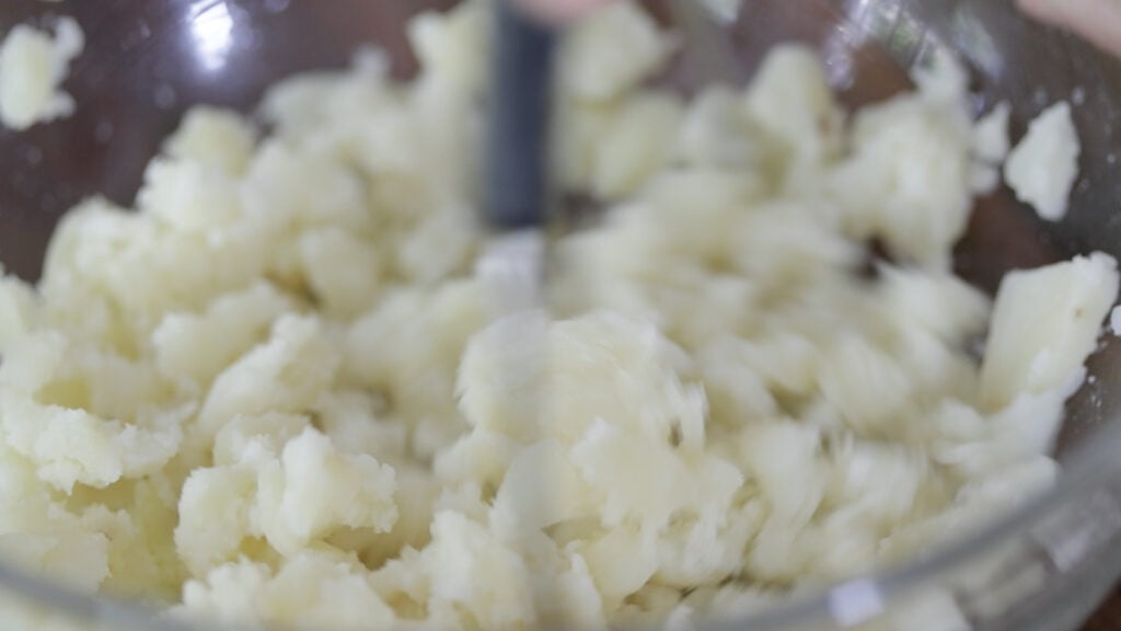 mashing potatoes in a bowl