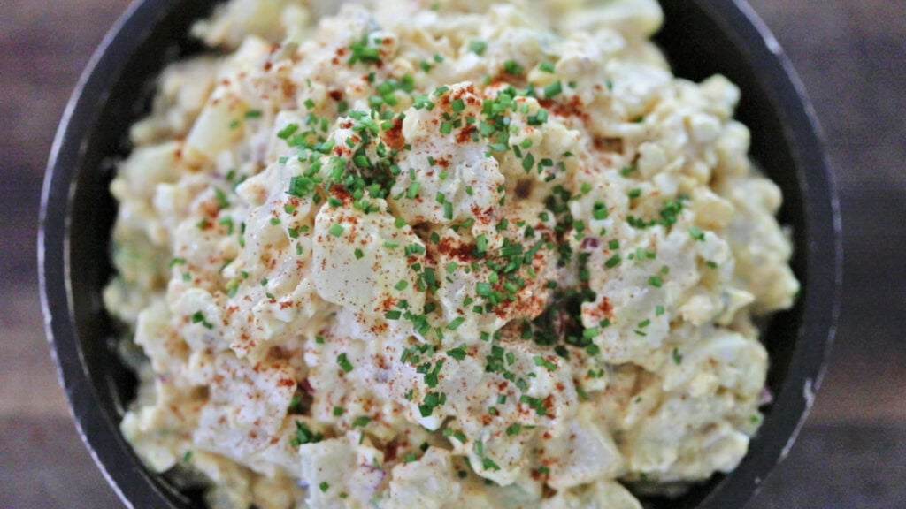 garnishing potato salad with chives