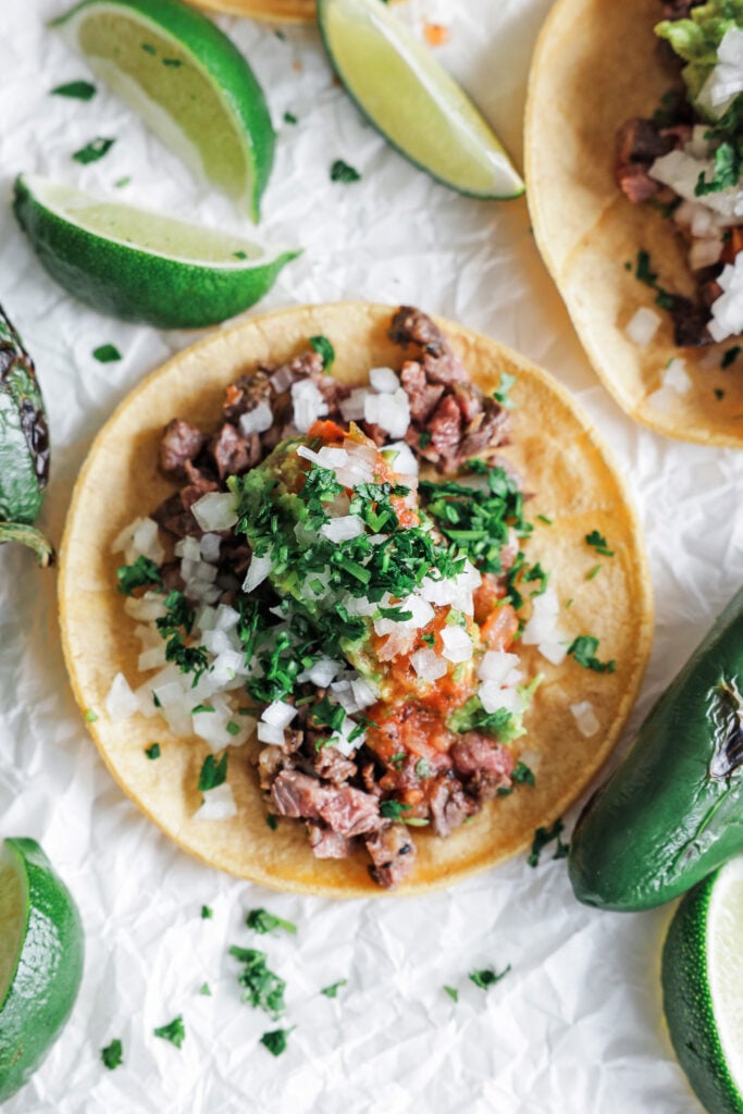 Steak Taco with lime wedges around it 