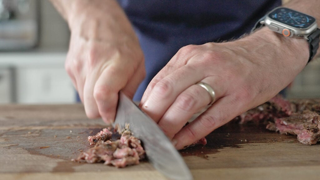 sliving steak on a wooden cutting board