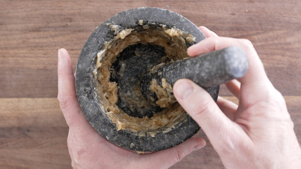 Using a mortar and pestle to grind ingredients