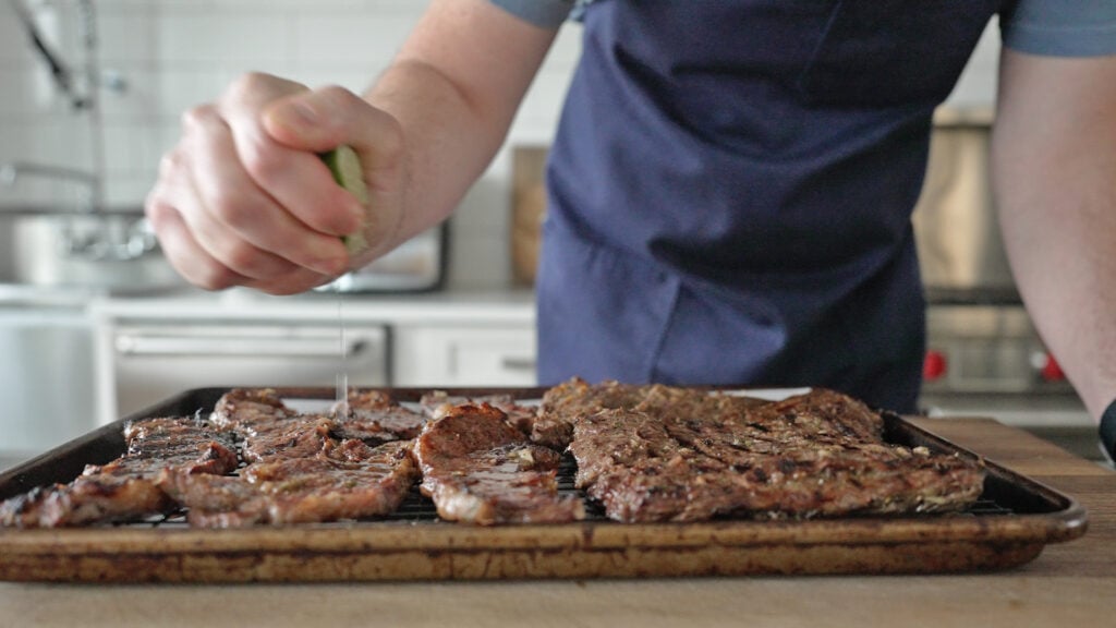 squeezing lime over cooked steak