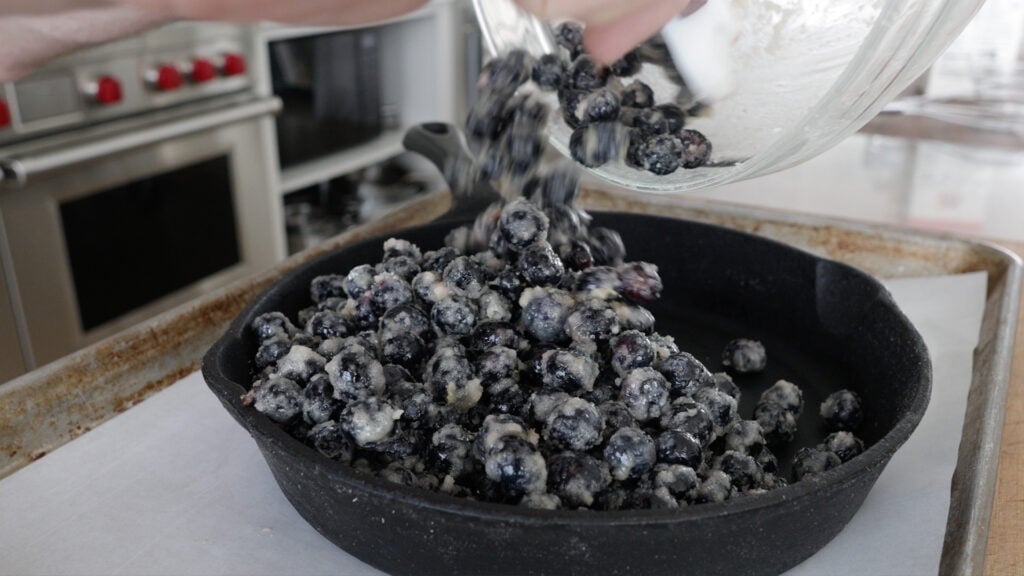 Pouring the blueberry mixture into a cast iron skillet