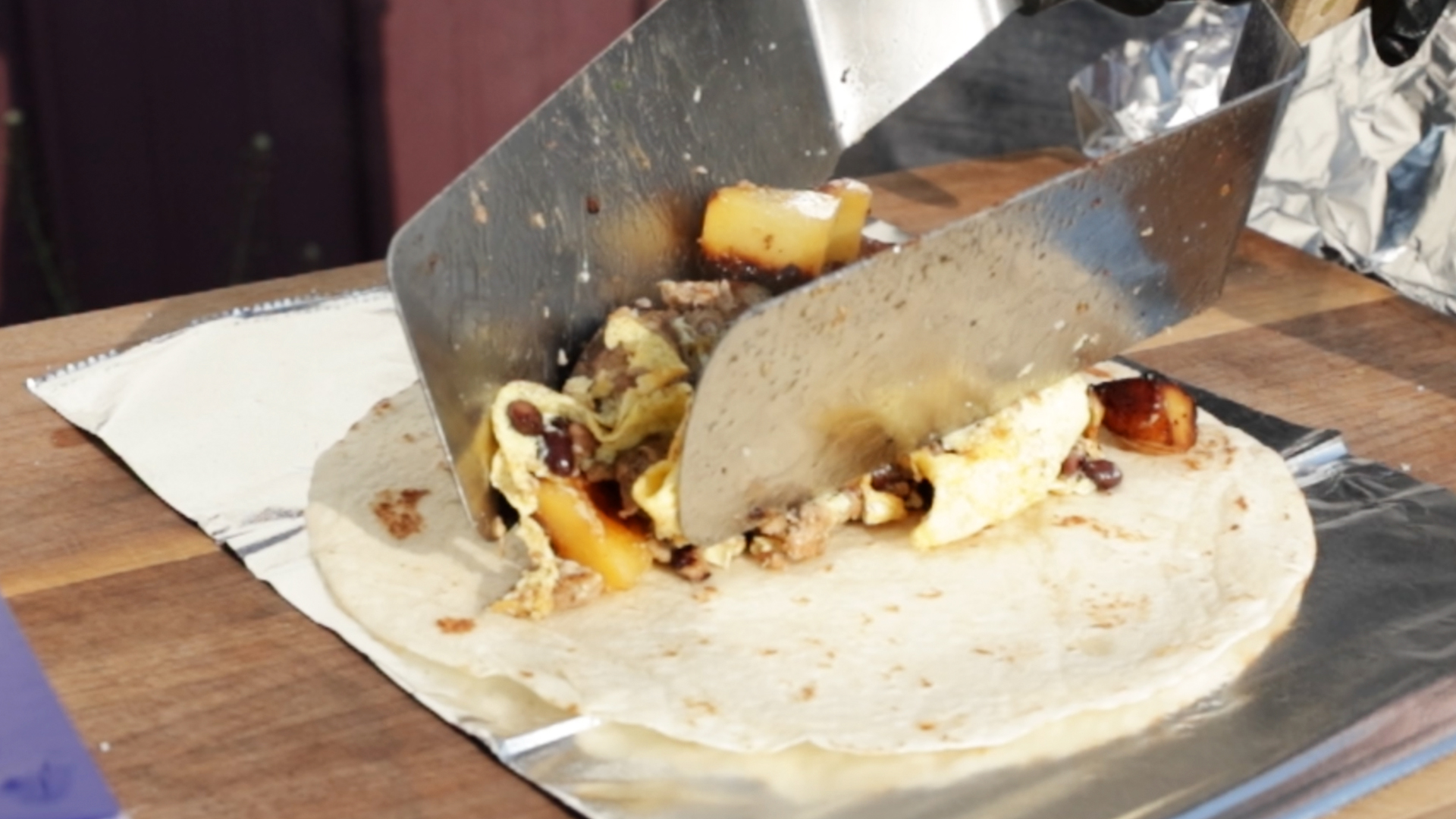 cooked breakfast burrito ingredients in a flour tortilla