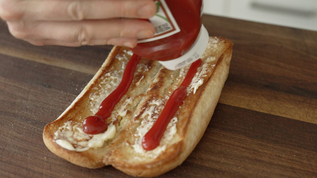 Lines of ketchup on a sandwich roll