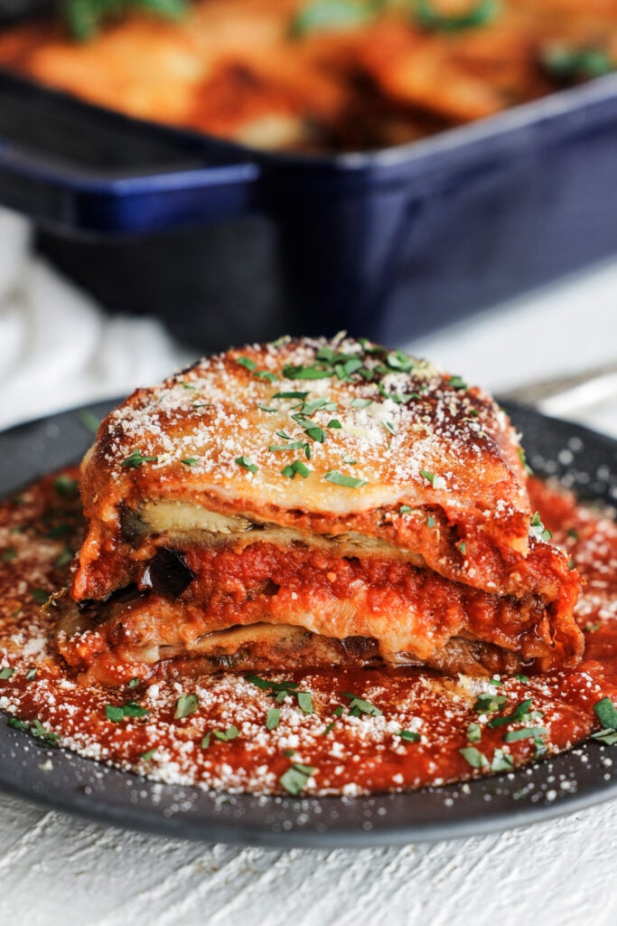 eggplant parmesan served with chopped basil on top  