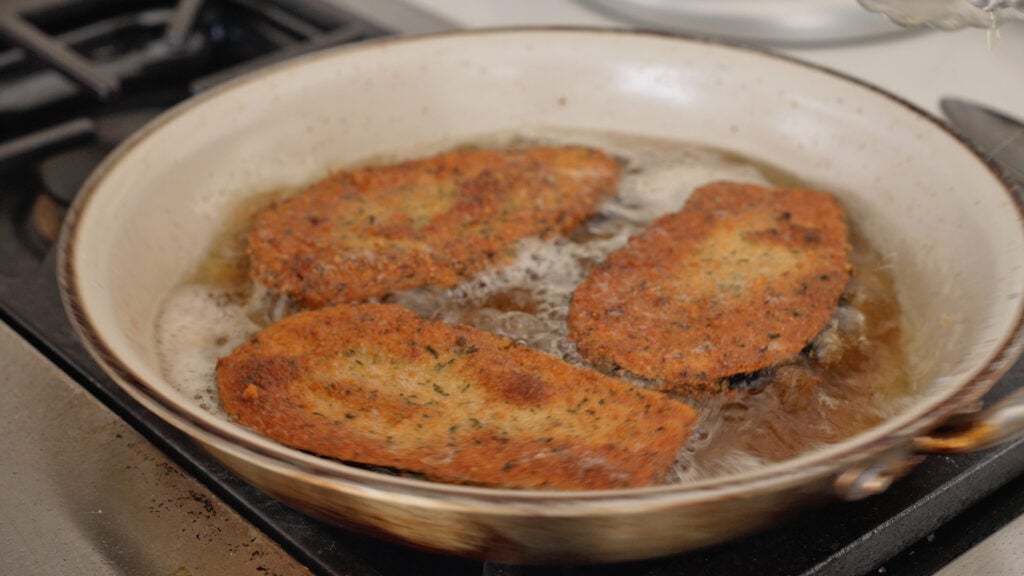 frying the breaded eggplants