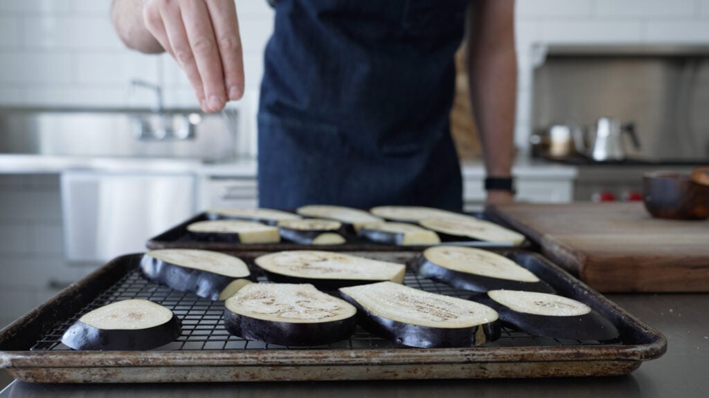 seasoning the sliced eggplants