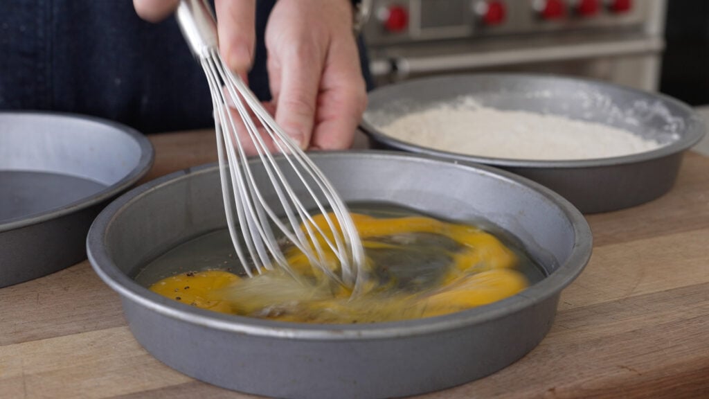 whisking eggs in a cake tin 