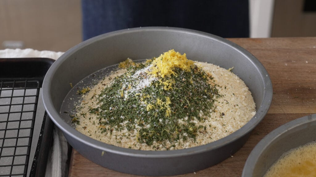 Breadcrumbs and the remaining breading ingredients in a cake tin.