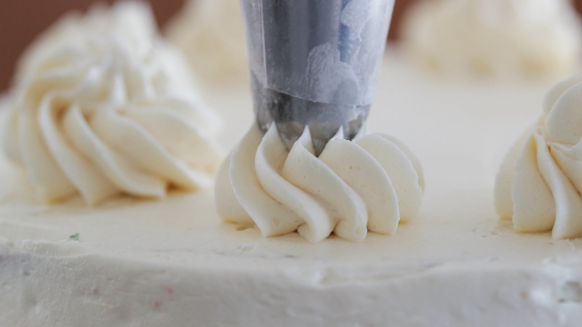 piping buttercream onto a cake