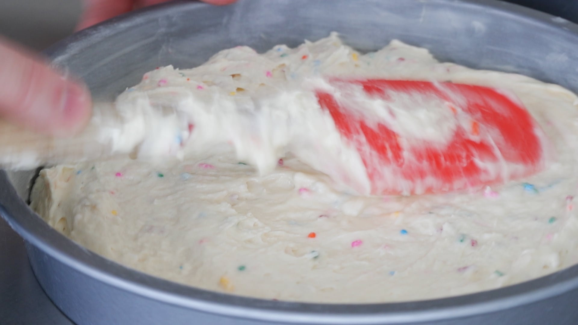 adding batter to cake pans
