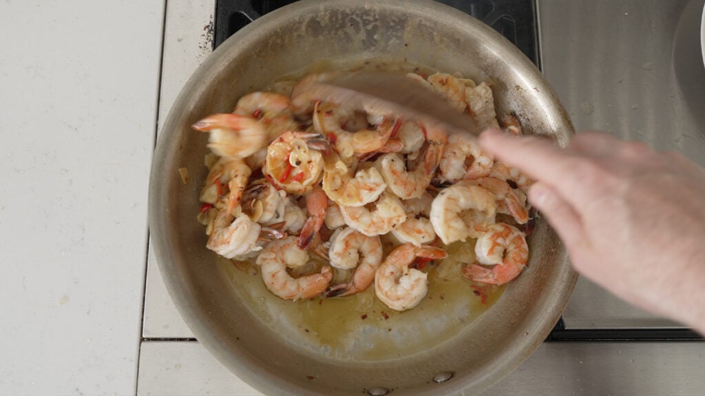 adding shrimp back into the pan