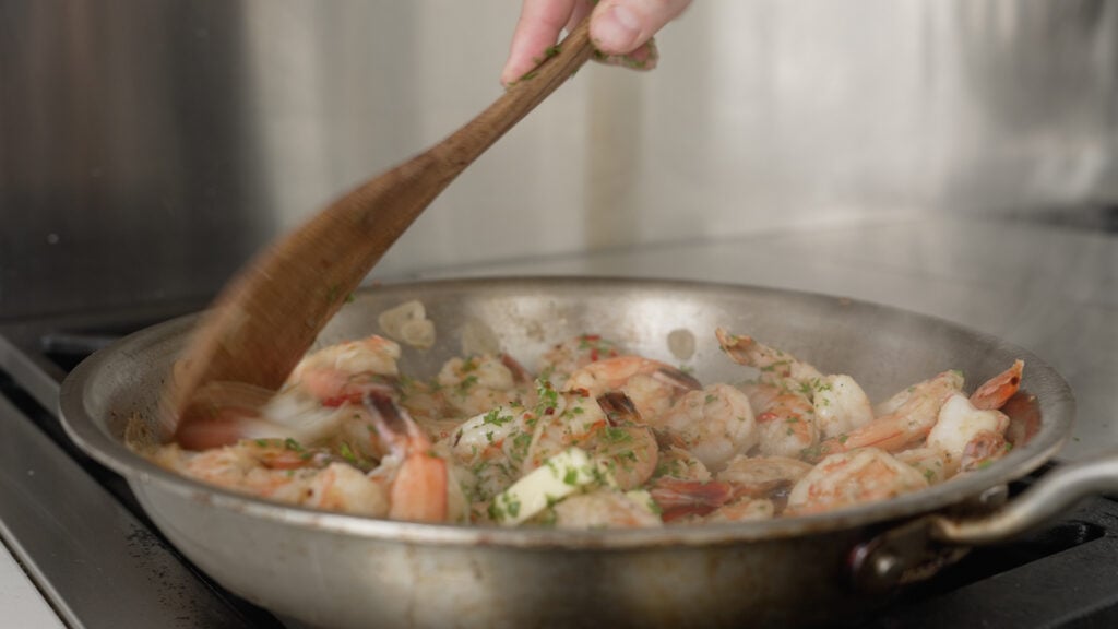 stirring the ingredients in the pot topped with parsley and butter