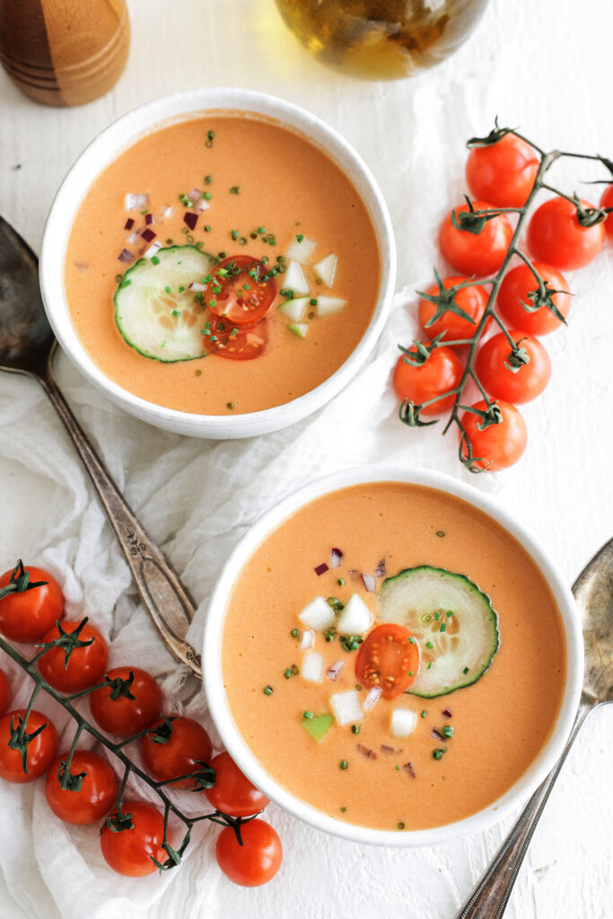 gazpacho serve in two bowls with fresh toppings