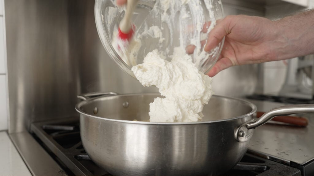Adding the cheese-lemon mixture to a large pot