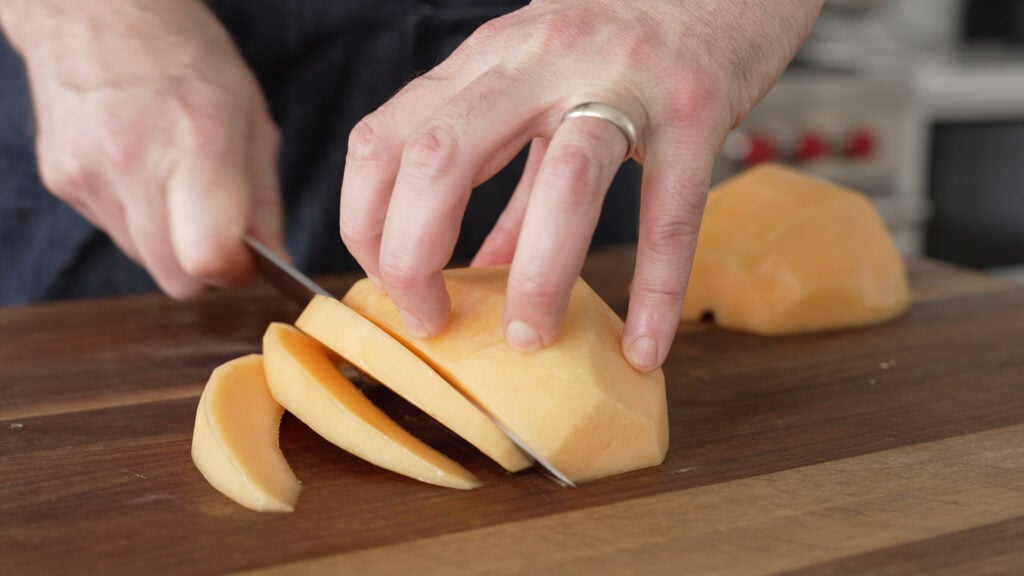 Slicing a peeled melon into wedges