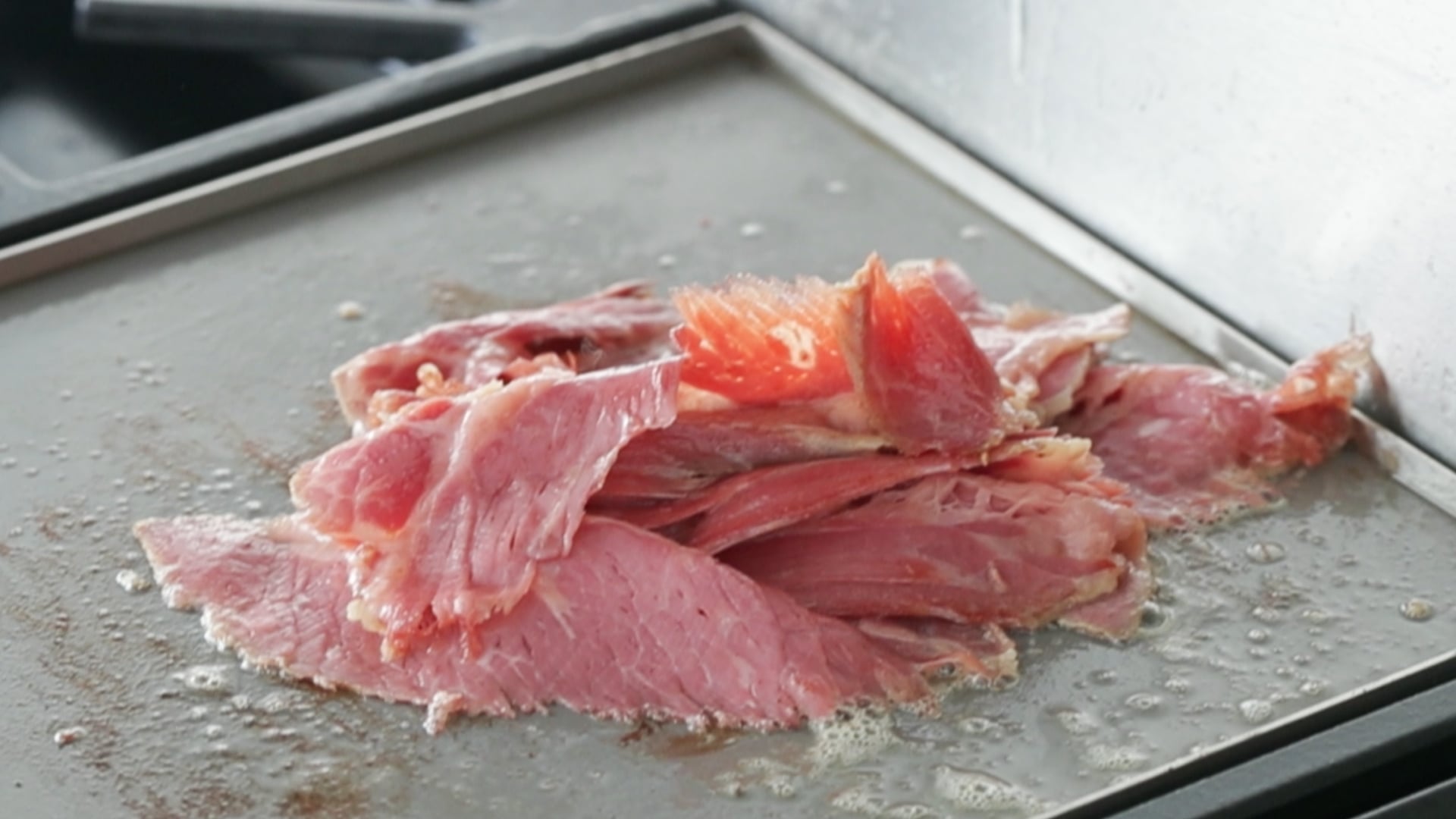 slices of corned beef cooking