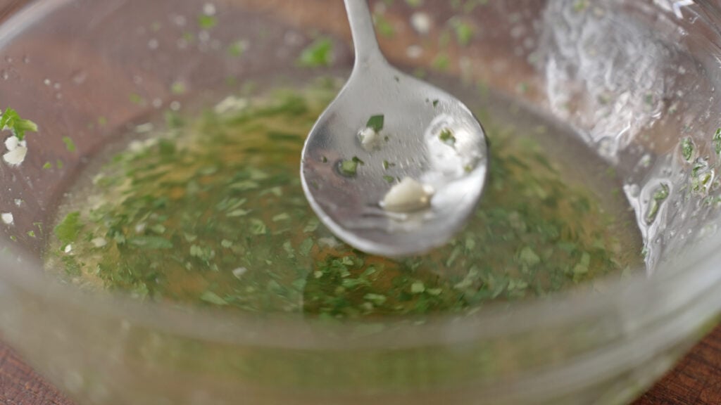 salad ingredients in a glass bowl with a spoon in it