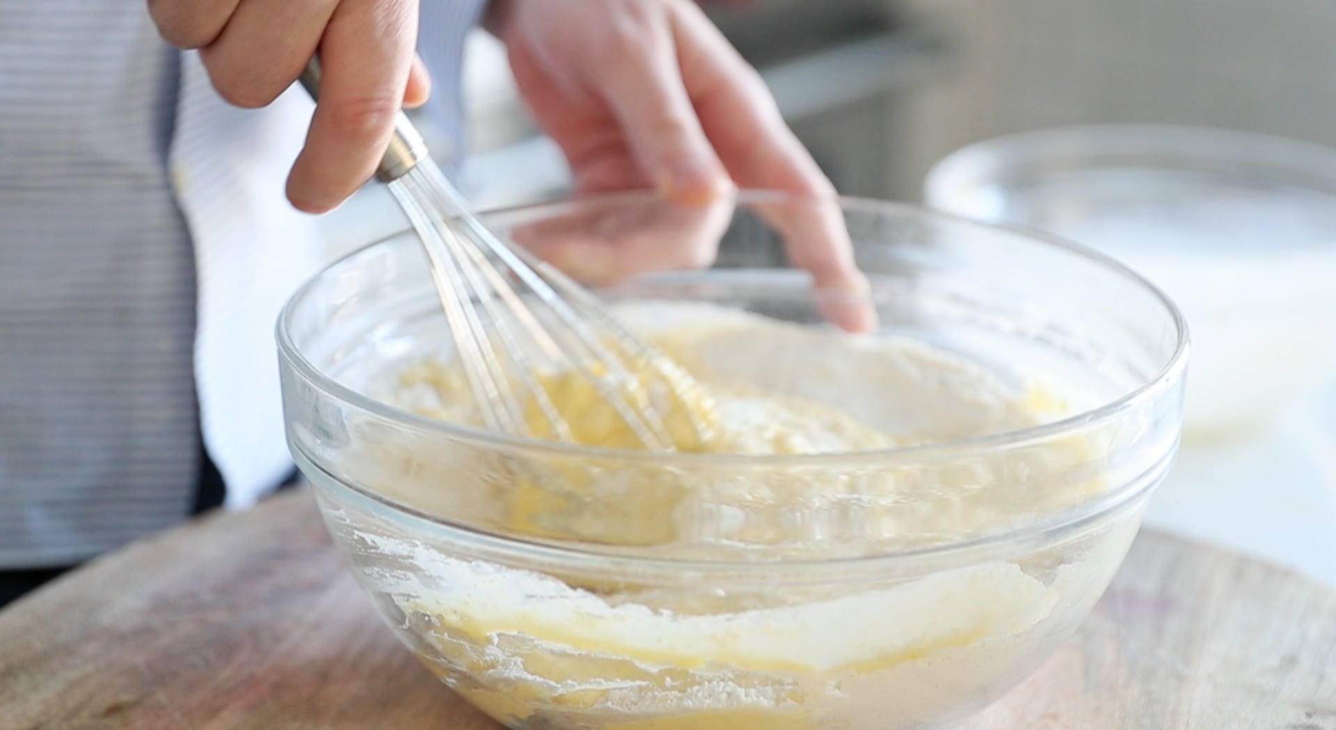 adding milk to a bowl of flour