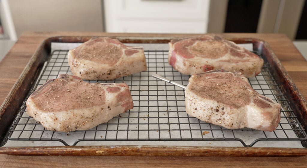 pork chops on a cookie sheet tray ready to sear