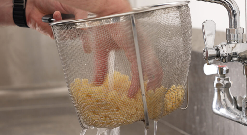 cooling down cooked pasta under cold water