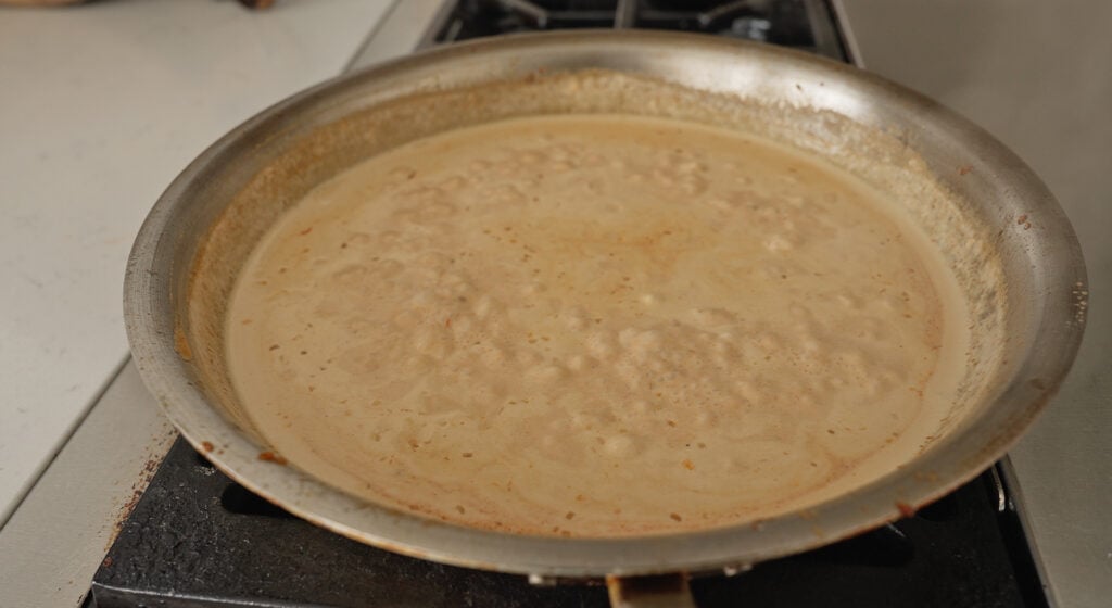 reducing the sauce in a pan
