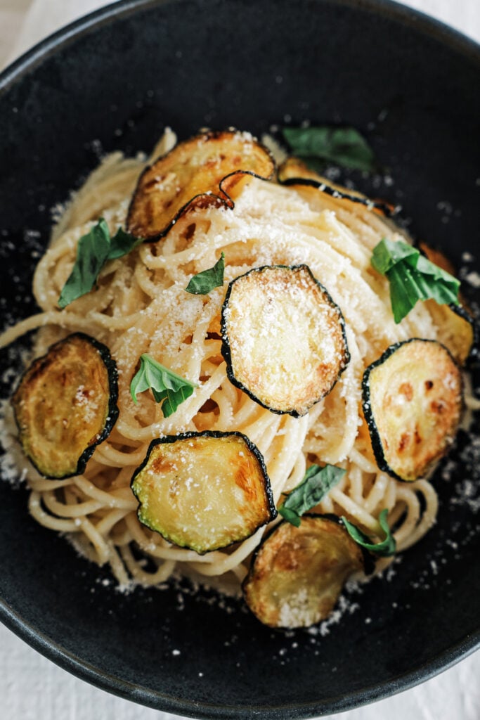 Spaghetti alla nerano served on a black plate