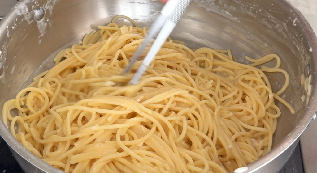 mixing the pasta with the cheeses