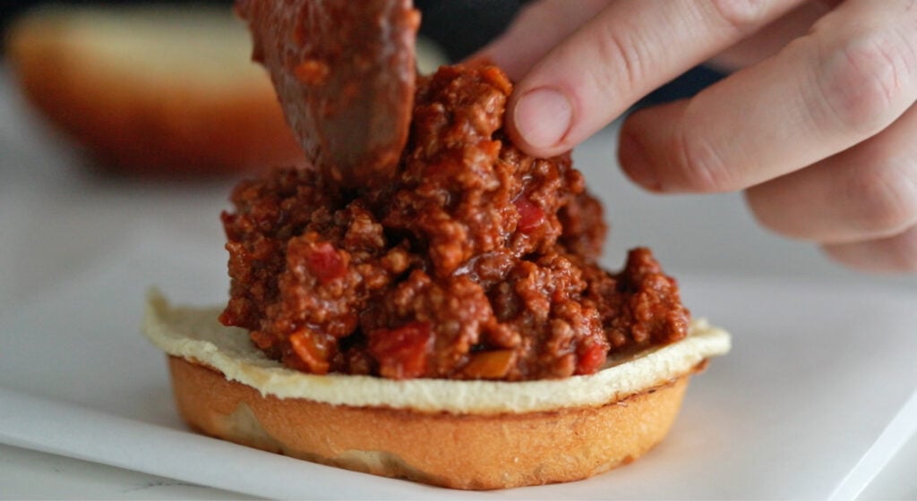Spooning the beef onto bun