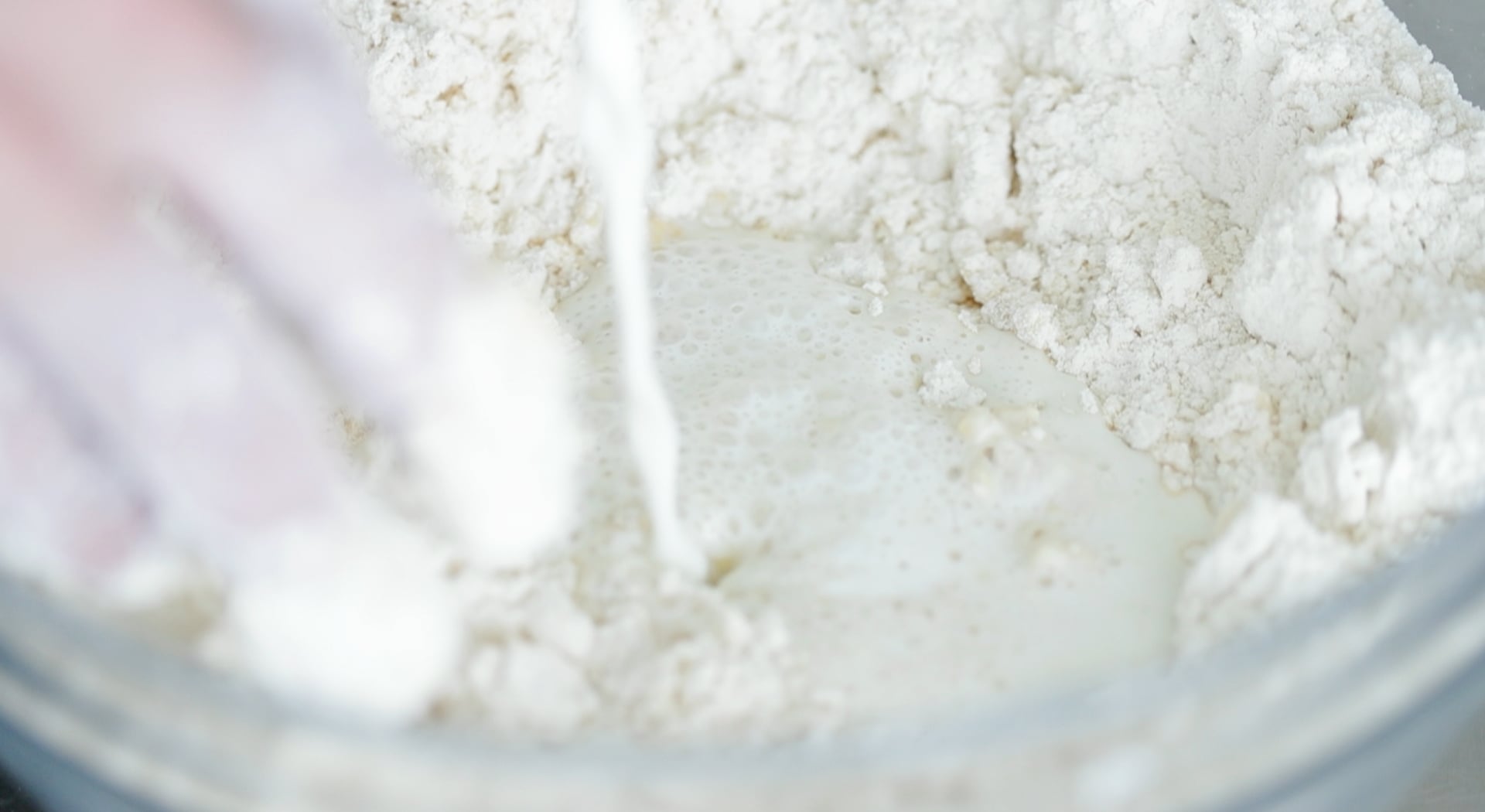 pouring milk into dough