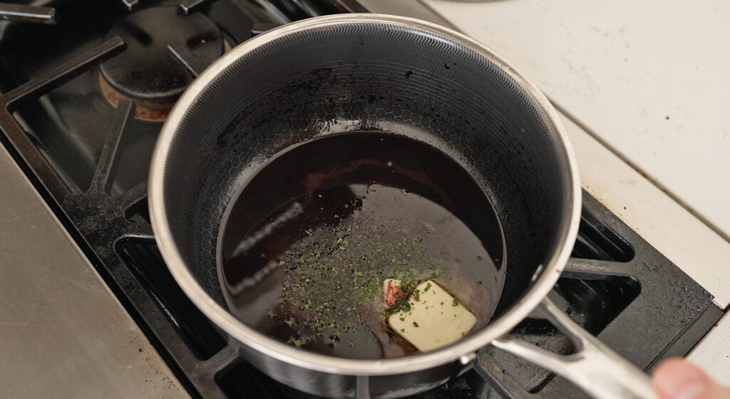 pouring reduced wine to the sauce mix